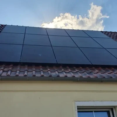 Einfamilienhaus Solaranlage mit Montage und Anmeldung: Auf dem Dach eines Einfamilienhauses wurde eine moderne Solaranlage fachgerecht montiert. Die dunkel gehaltenen Solarmodule fügen sich harmonisch in das Dachbild ein. Die vollständige Montage und Anmeldung der Anlage sorgt für eine reibungslose Inbetriebnahme und optimale Nutzung der Sonnenenergie. Komplette Photovoltaikanlage inkl. Montage und Anmeldung