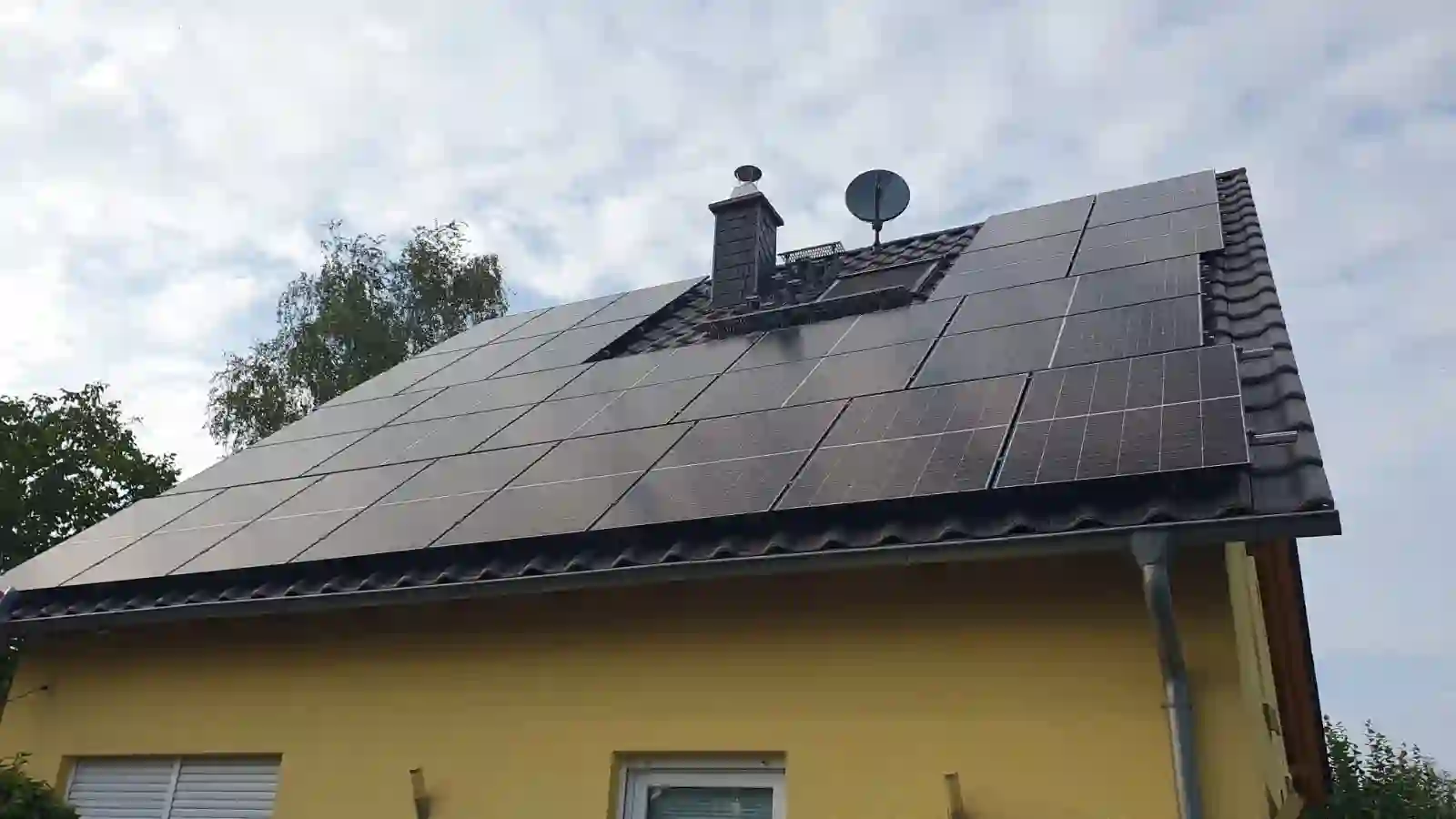 Weitere Perspektive des Hauses zeigt die vollständige Dachfläche mit dichter Solarbestückung. Einfamilienhaus Solaranlage mit Montage und Anmeldung.