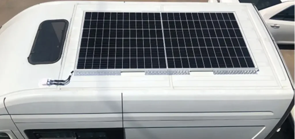 Auf dem Dach eines weißen Wohnmobils ist eine moderne Wohnmobil-Solaranlage montiert. Zwei große Solarmodule sorgen für die Stromversorgung unterwegs und machen das Fahrzeug unabhängig von externen Stromquellen