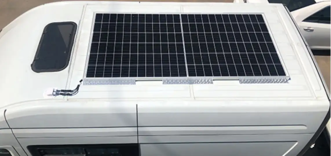 Auf dem Dach eines weißen Wohnmobils ist eine moderne Wohnmobil-Solaranlage montiert. Zwei große Solarmodule sorgen für die Stromversorgung unterwegs und machen das Fahrzeug unabhängig von externen Stromquellen